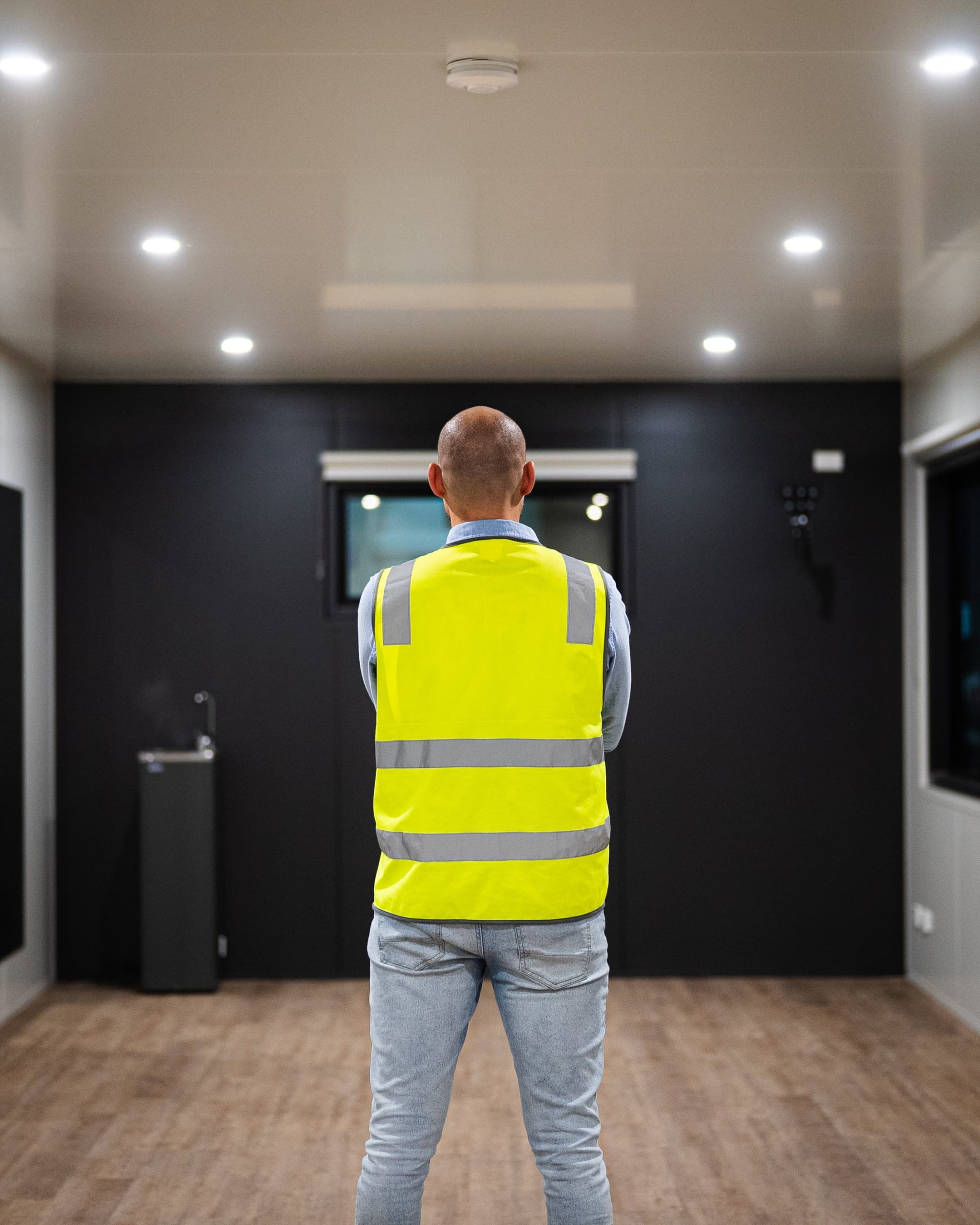 Man standing in the middle of extra wide container office building.